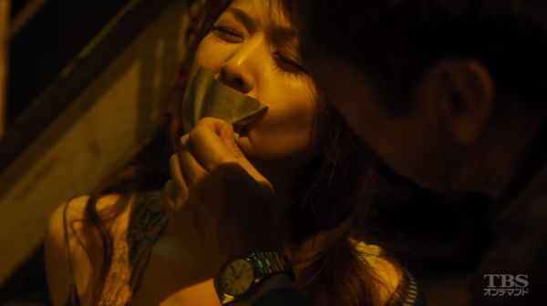 飯島直子の口のダクトテープを香川照之が剥がそうとしている